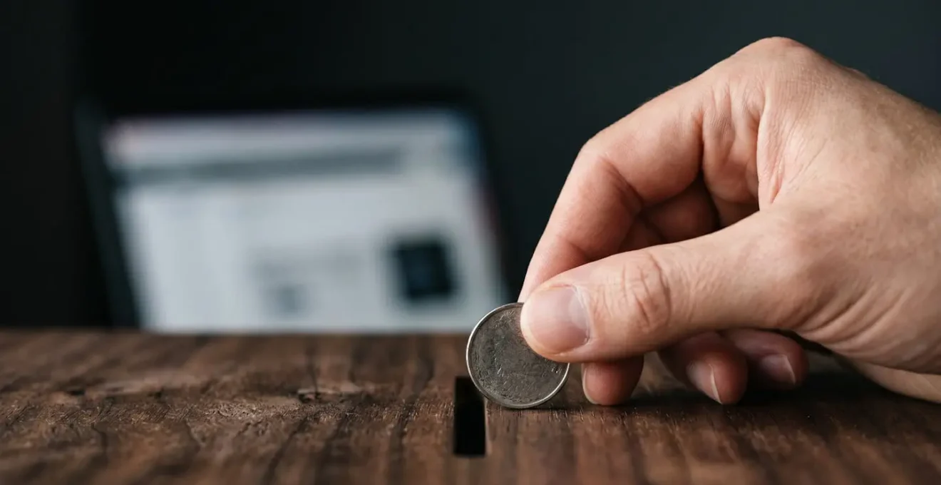 Gros plan artistique sur une pièce de monnaie déposée avec précision, symbolisant le coût élevé de chaque clic publicitaire en référencement payant