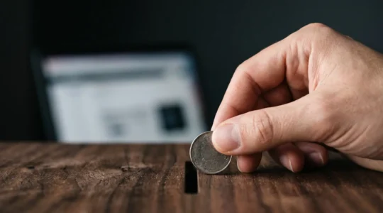 Gros plan artistique sur une pièce de monnaie déposée avec précision, symbolisant le coût élevé de chaque clic publicitaire en référencement payant