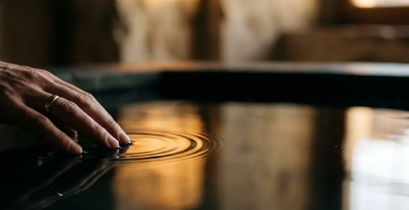 Une main effleure une surface lumineuse et ondulante evoquant l'empreinte durable d'une emotion memorable laissee par une experience numerique